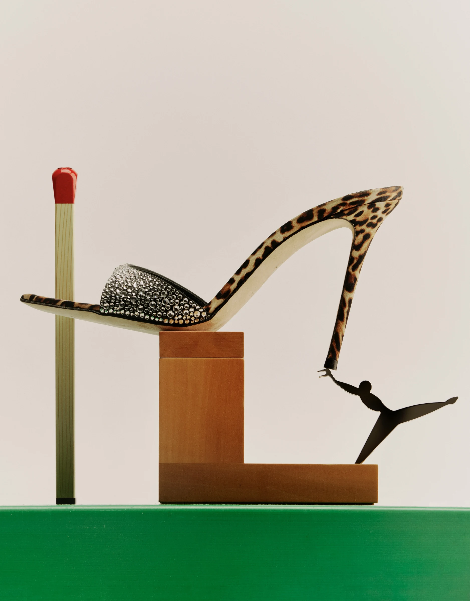 Leopard-pattern crystal mule in a sculptural still-life arrangement