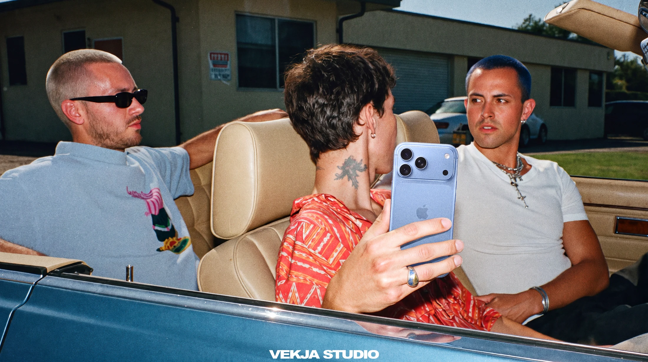 Three friends with a phone in a convertible