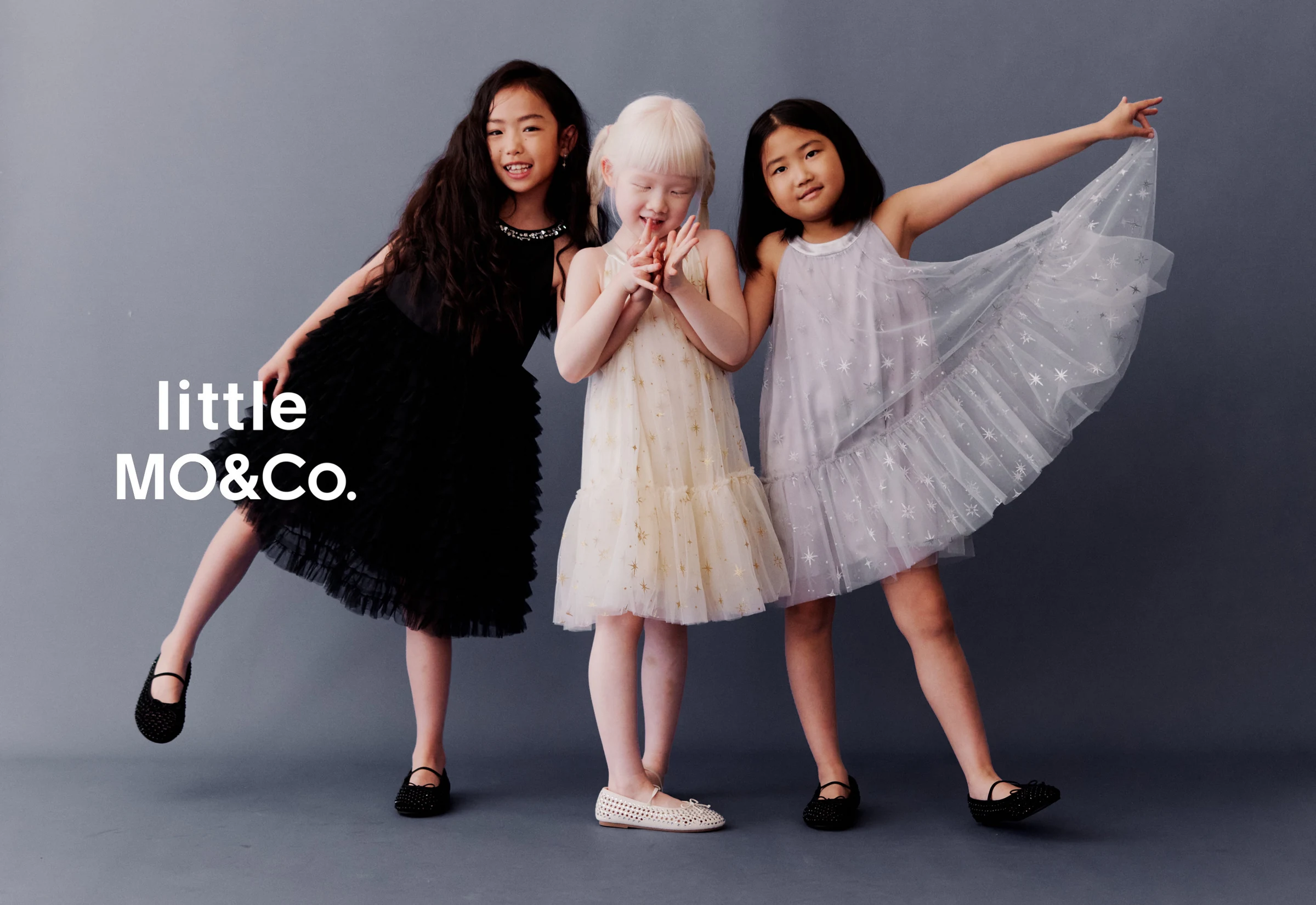 Three girls posing together in little MO&Co. dresses