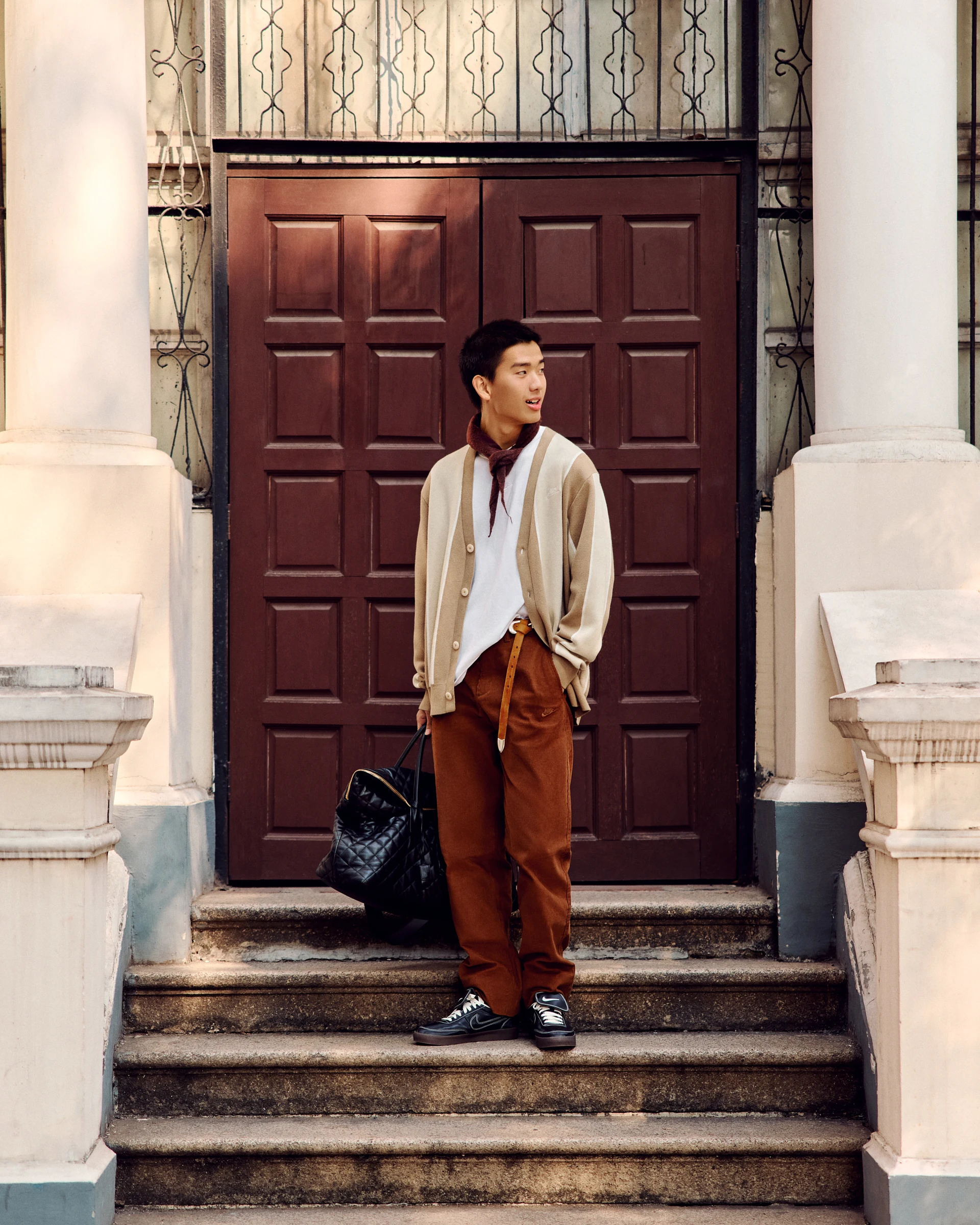 NIKE streetwear portrait on steps outside a wooden door