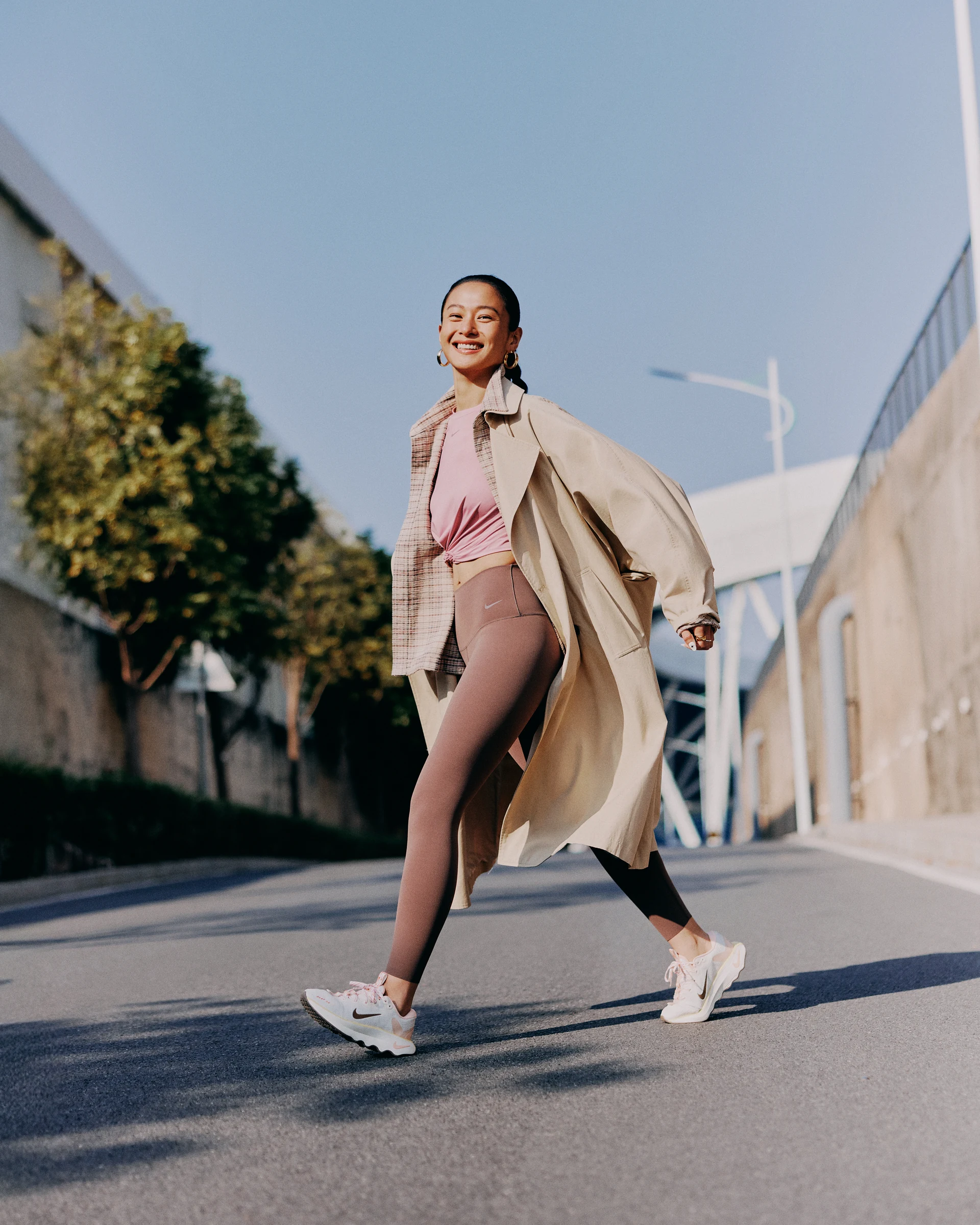 NIKE portrait of a woman walking in a light coat