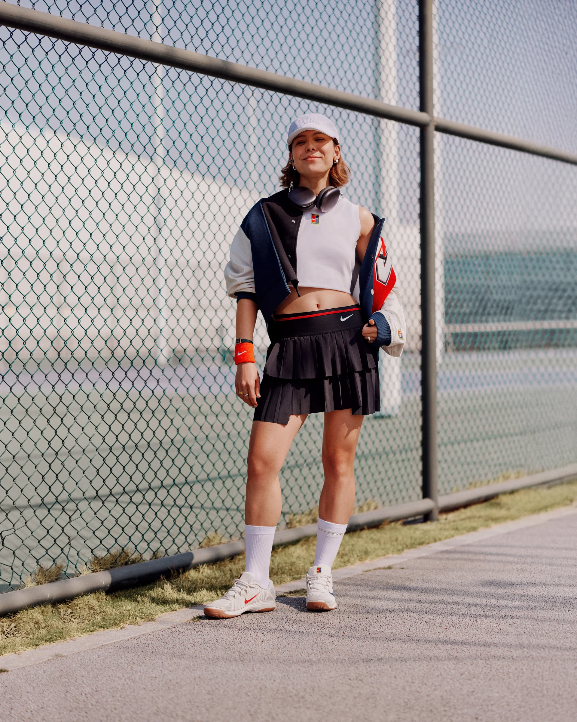 NIKE tennis-inspired portrait beside a chain-link fence
