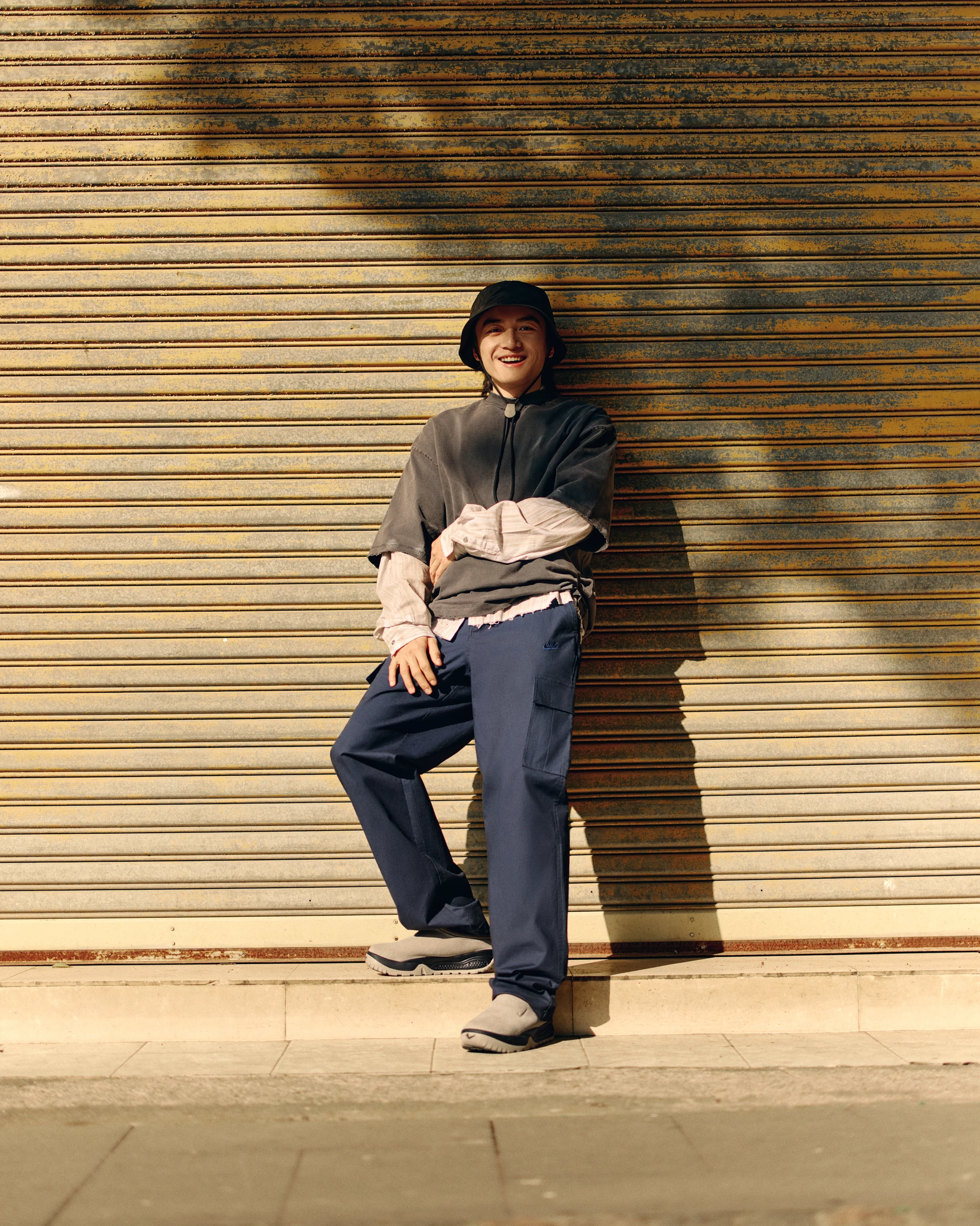 NIKE streetwear portrait against a yellow shutter