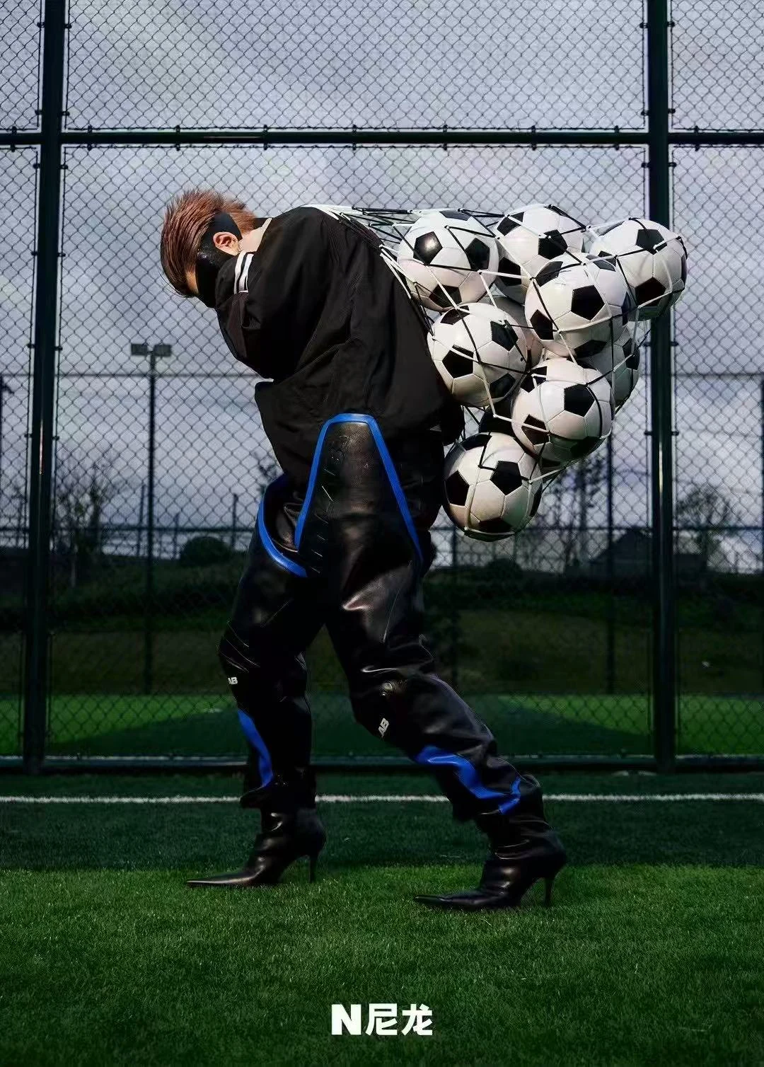 Capper carrying a net of footballs for NYLON