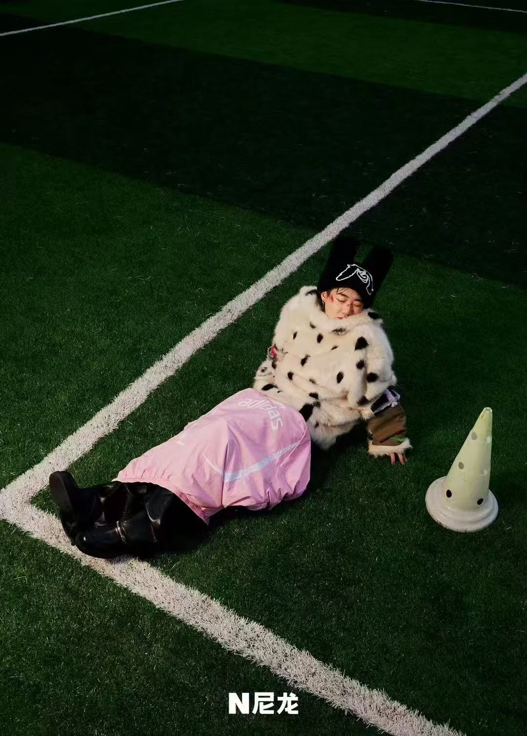 Capper reclining beside the pitch markings for NYLON